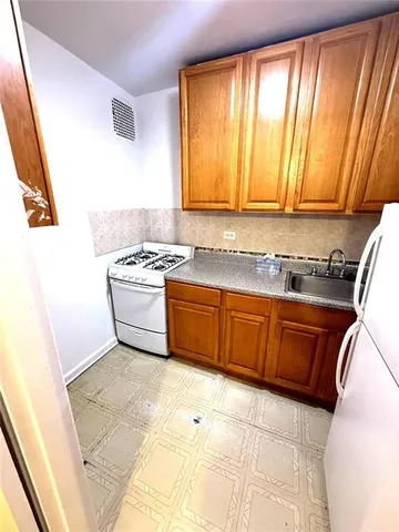 a kitchen with a sink a stove and cabinets
