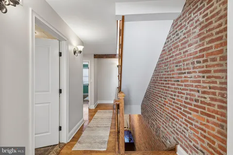 a view of a hallway with wooden floor and staircase