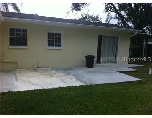 a view of an house with backyard space and tree