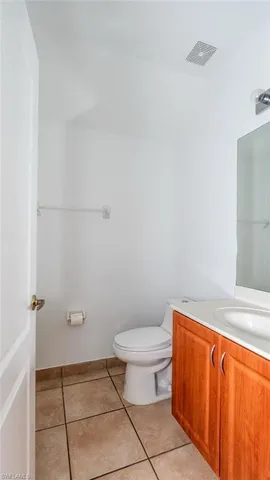 a bathroom with a granite countertop toilet and a sink