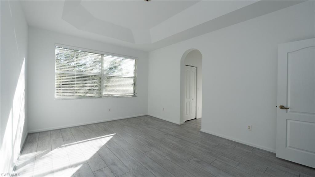 Undisclosed Address Naples, FL 34119 - Photo 4 of 20 an empty room with wooden floor and windows