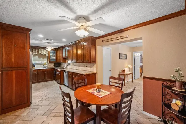 a kitchen with a dining table chairs stainless steel appliances and cabinets