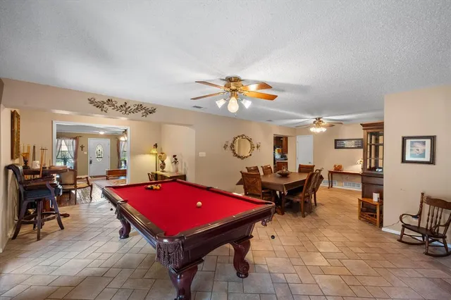 a living room with furniture pool table and a large window