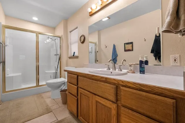a bathroom with a double vanity sink toilet and shower