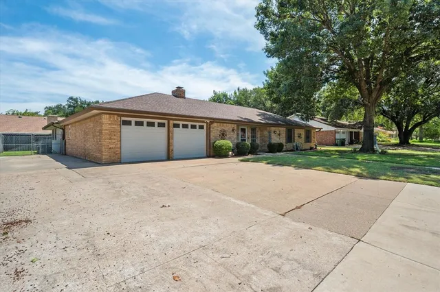 a view of house with backyard and trees in the background
