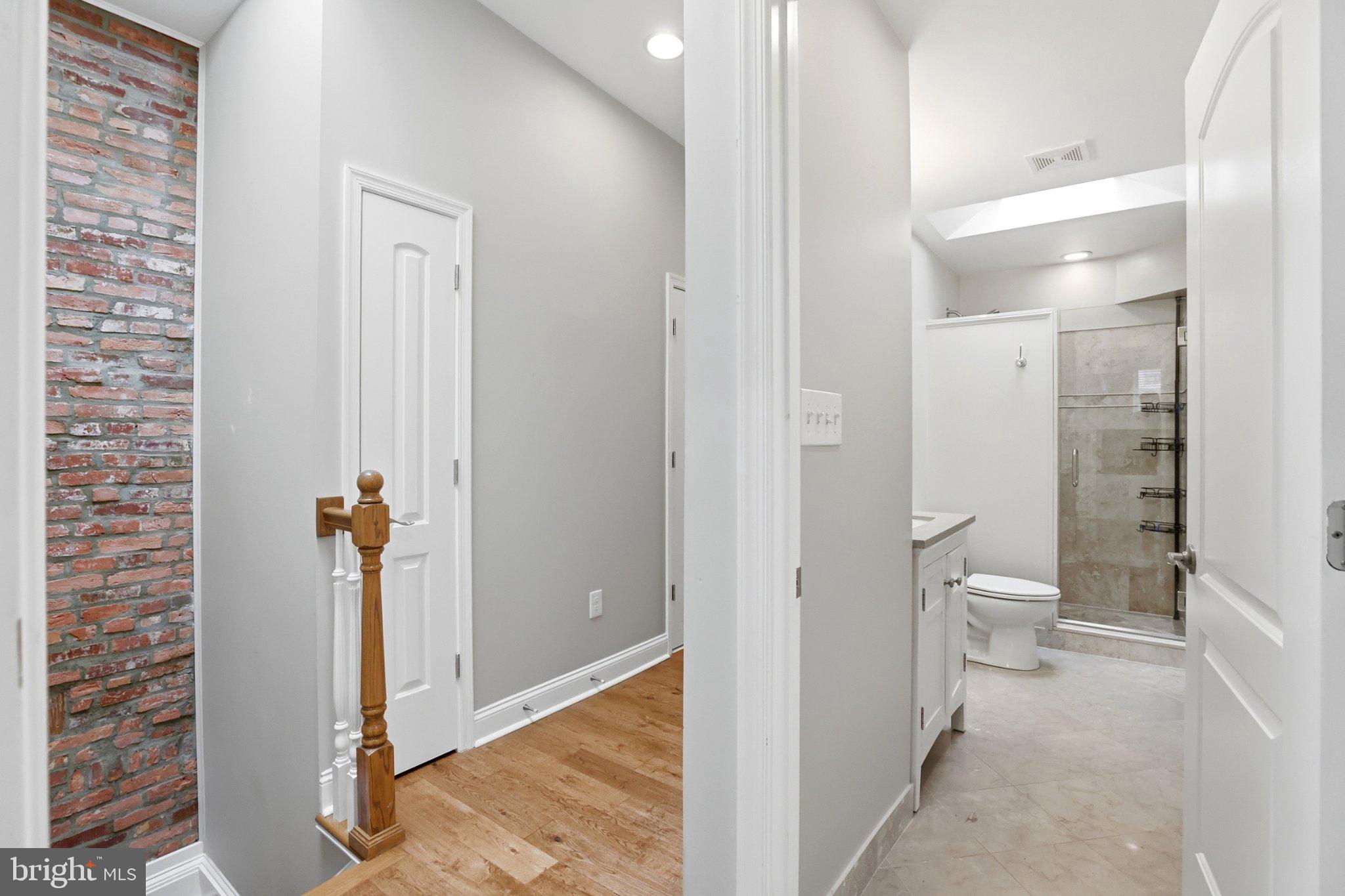 222 South Exeter Street Baltimore, MD 21202 - Photo 13 of 41 a bathroom with a granite countertop toilet a sink and shower