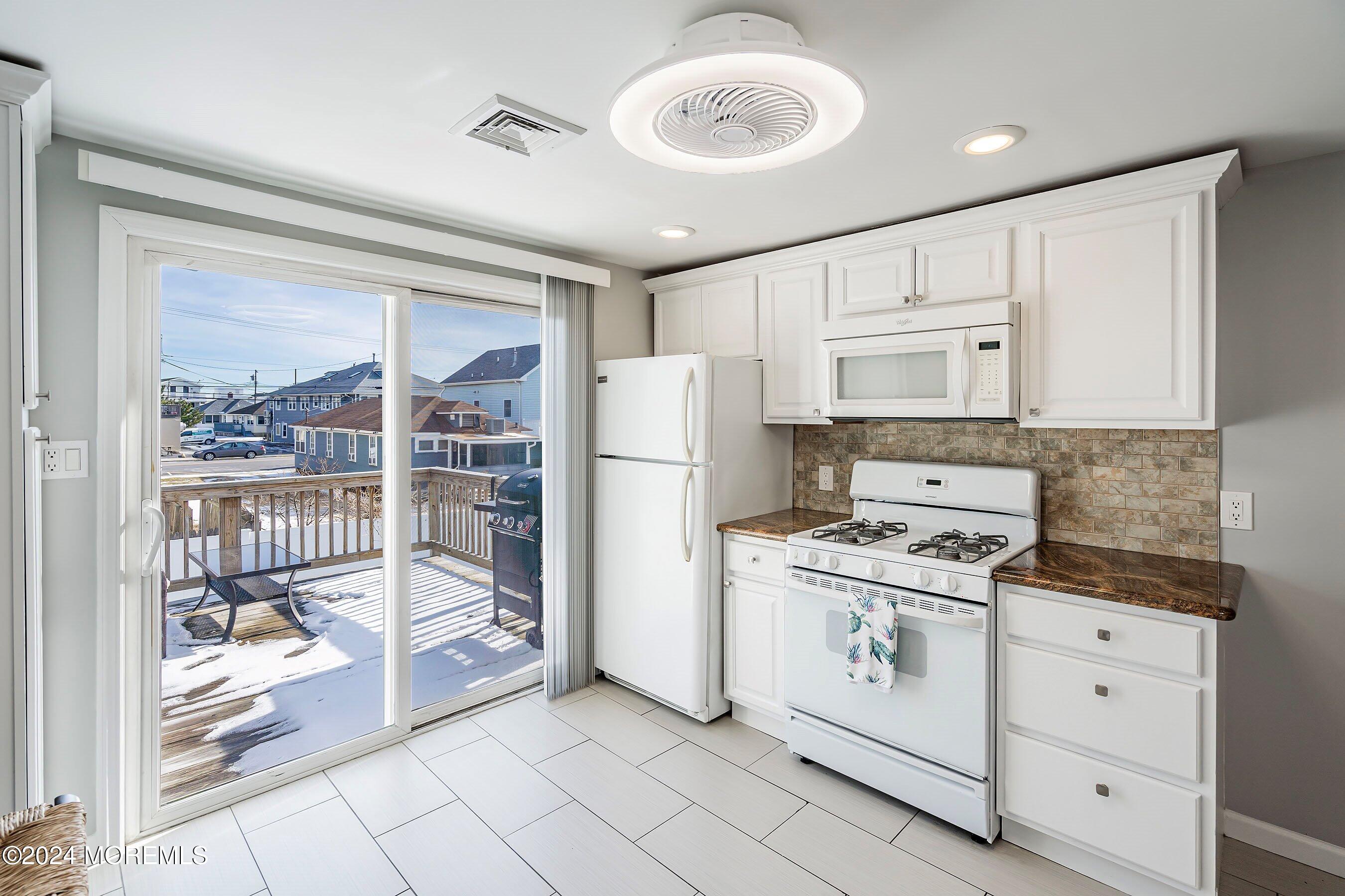 212 Randall Avenue Point Pleasant Beach, NJ 08742 - Photo 8 of 18 a kitchen with a stove a refrigerator and white cabinets