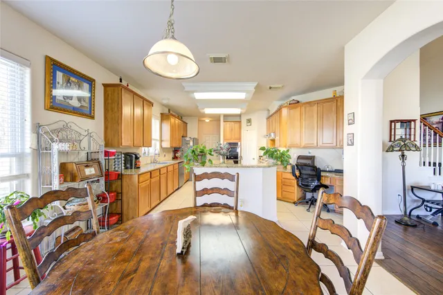 a kitchen with stainless steel appliances granite countertop sink window and chairs