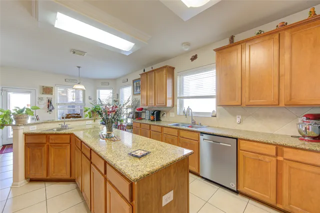 a large kitchen with stainless steel appliances lots of counter space and a sink