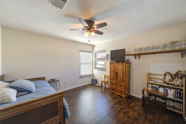 a bedroom with a bed and wooden floor