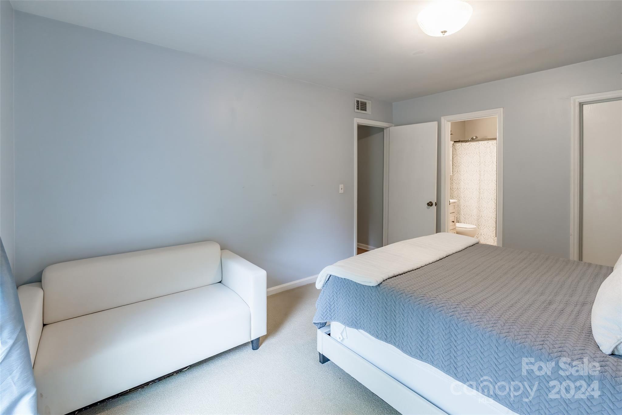 430 Queens Road, Unit 322 Charlotte, NC 28207 - Photo 12 of 20 a bedroom with a bed and a couch