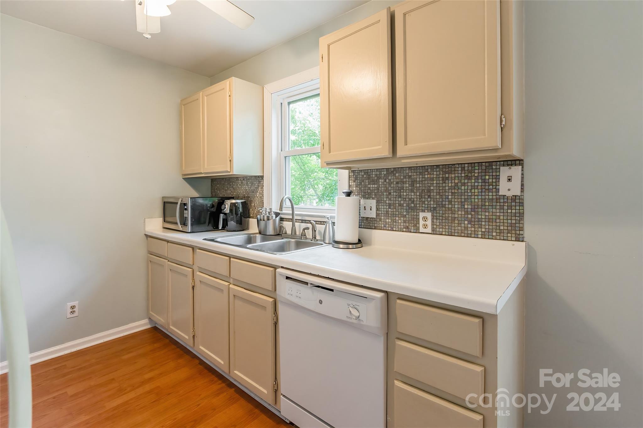430 Queens Road, Unit 322 Charlotte, NC 28207 - Photo 9 of 20 a kitchen with white cabinets sink and window