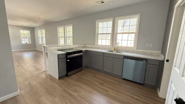 a large kitchen with granite countertop a sink and cabinets