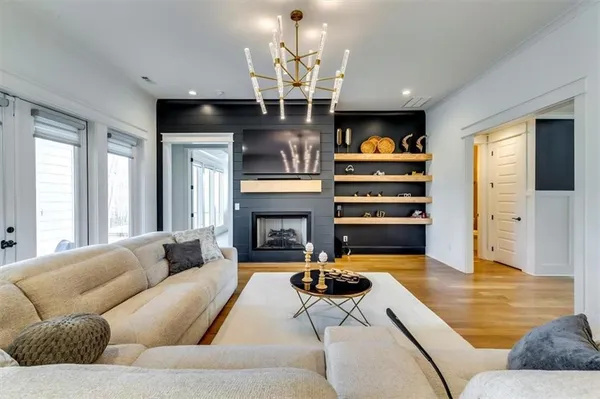 a living room with fireplace furniture and a chandelier