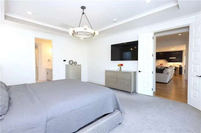 a bedroom with a large bed and a chandelier