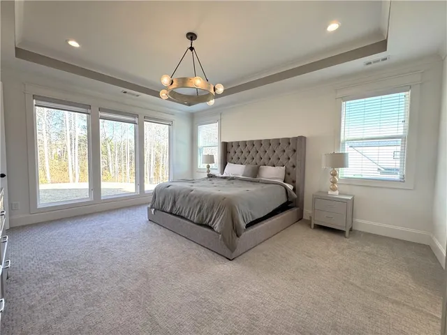 a spacious bedroom with a bed and a flat screen tv