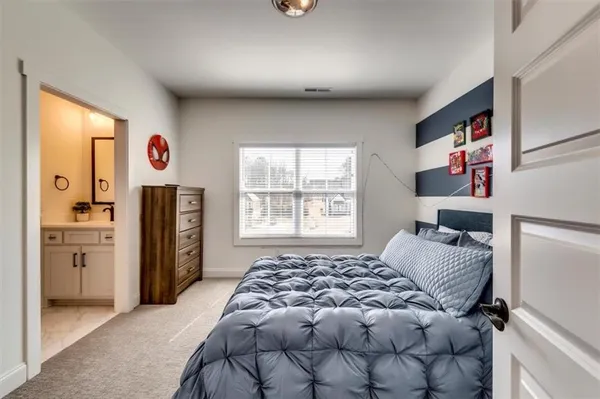 a spacious bedroom with a bed and a flat screen tv