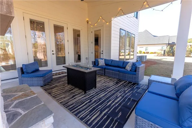 a view of a white house with large windows and a yard