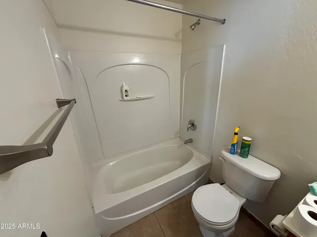 a white toilet sitting next to a bath tub