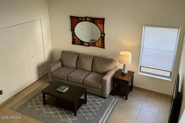 a living room with furniture a mirror and a lamp