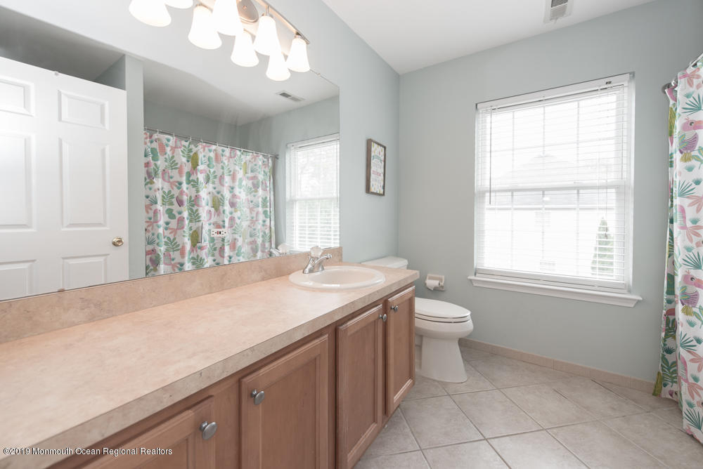 11 Round Hill Road Jackson, NJ 08527 - Photo 64 of 69 a bathroom with a granite countertop sink a toilet and a window