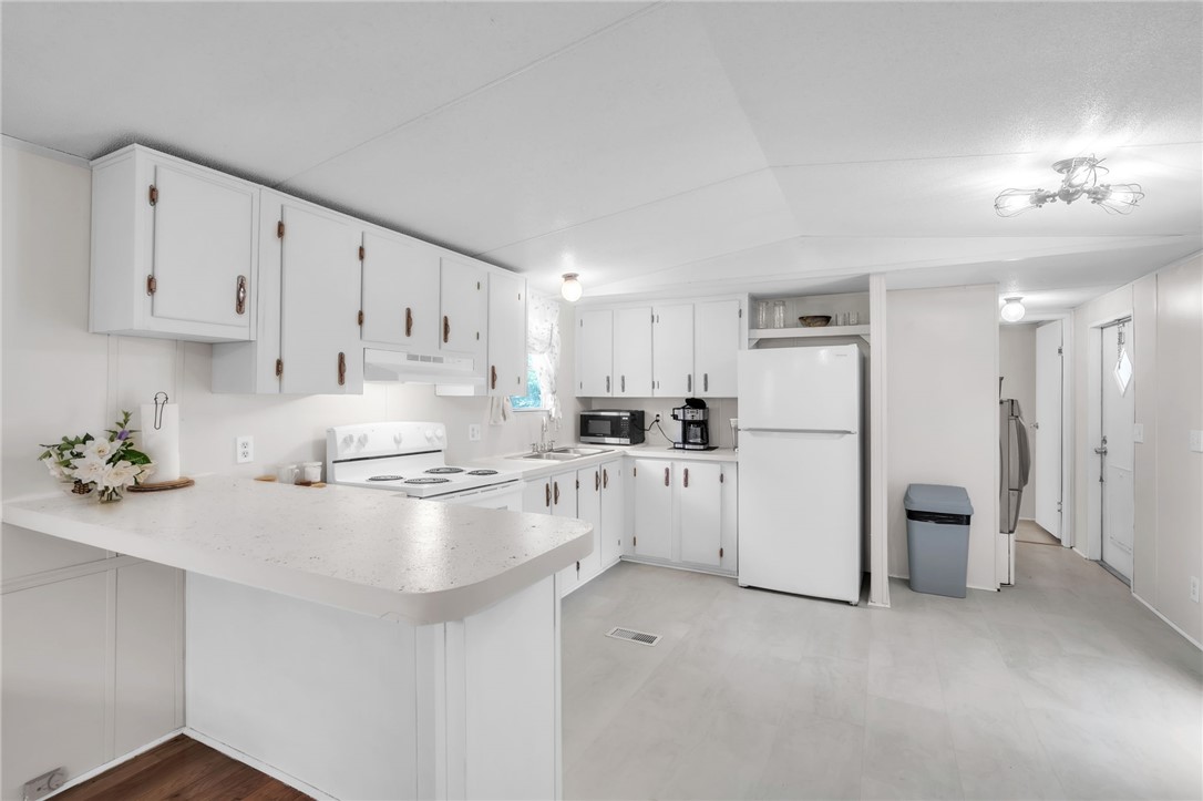 506 Charlies Creek Road Iva, SC 29655 - Photo 12 of 28 A well-equipped kitchen features white cabinetry and bright, clean finishes, ideal for daily living.