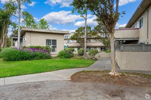 a house with green field in front of it