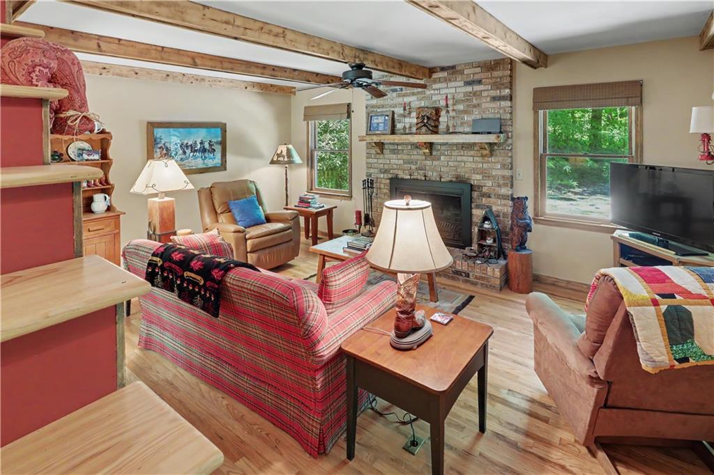 102 Moses Road Rabun Gap, GA 30568 - Photo 28 of 40 a living room with furniture a fireplace and a flat screen tv