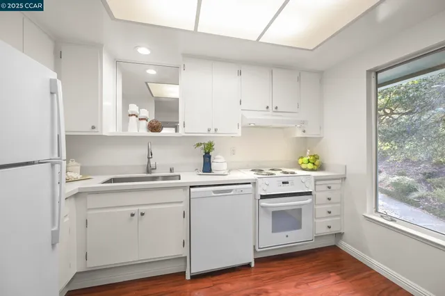 a kitchen with cabinets appliances and a window