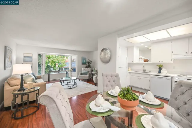 a view of a dining room with furniture a rug and wooden floor