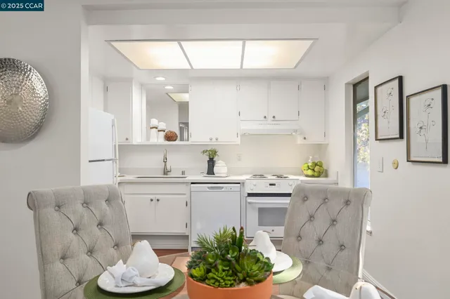 a kitchen with stainless steel appliances kitchen island granite countertop a sink a stove a dining table and chairs