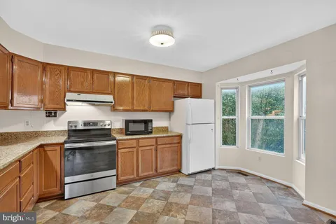 a kitchen with granite countertop appliances cabinets and a sink