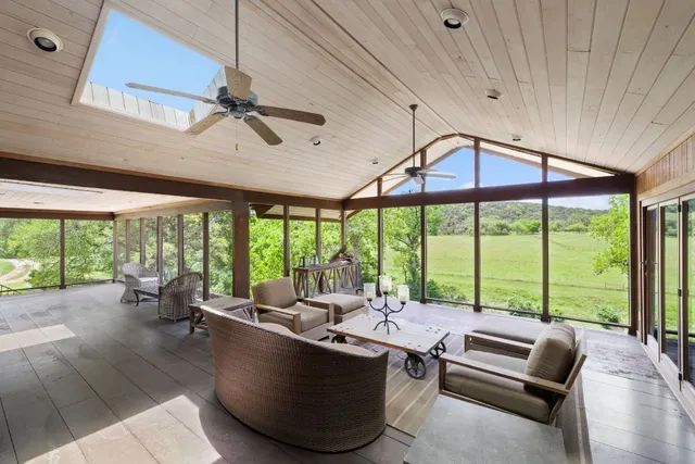 a living room with furniture and floor to ceiling windows