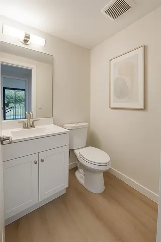 a bathroom with a toilet a sink and mirror