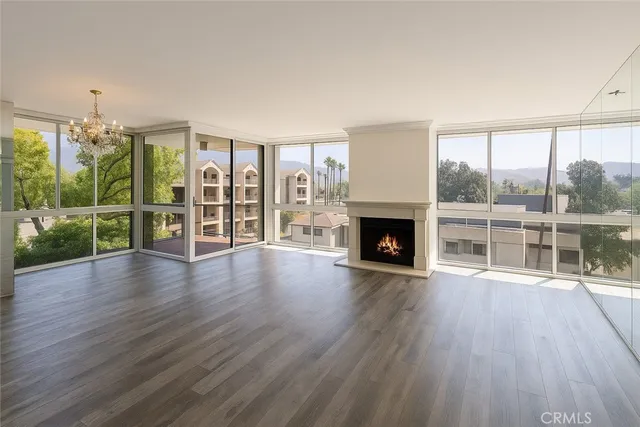 an empty room with floor to ceiling window and wooden floor