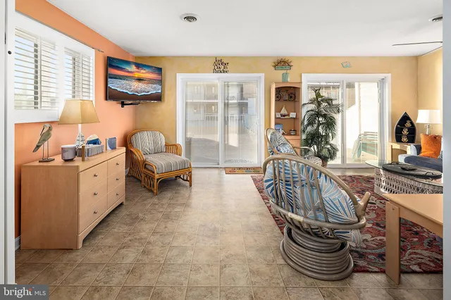a living room with furniture a flat screen tv and large windows
