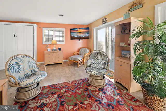 a living room with patio furniture and a potted plant