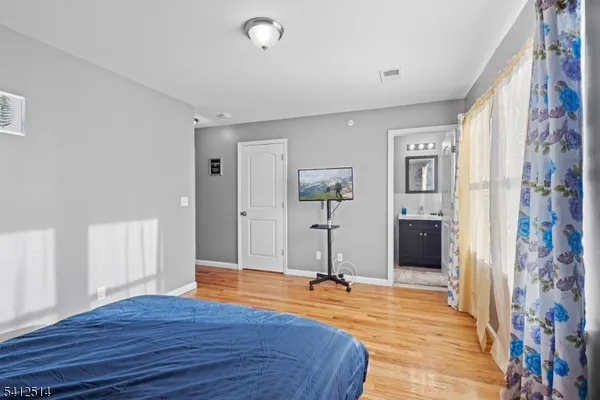 a bedroom with a bed and a wooden floor