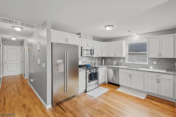 a kitchen with stainless steel appliances granite countertop a refrigerator and a sink