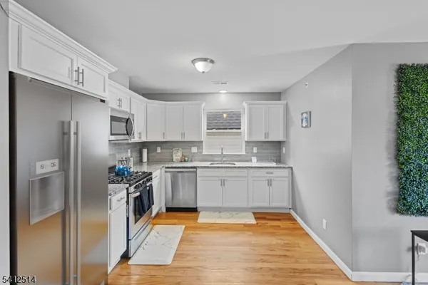 a kitchen with stainless steel appliances granite countertop a refrigerator and a stove top oven
