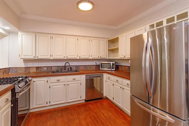 a kitchen with granite countertop white cabinets and white appliances