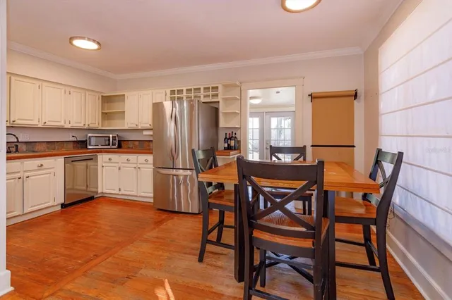a kitchen with a table chairs sink and refrigerator