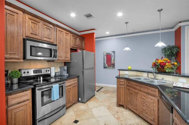 a kitchen with stainless steel appliances granite countertop a refrigerator a stove a sink and a microwave