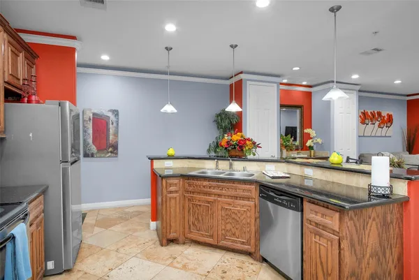 a kitchen with stainless steel appliances granite countertop a sink and a refrigerator