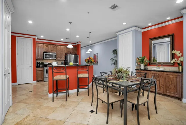 a view of kitchen with kitchen island dining table and stainless steel appliances