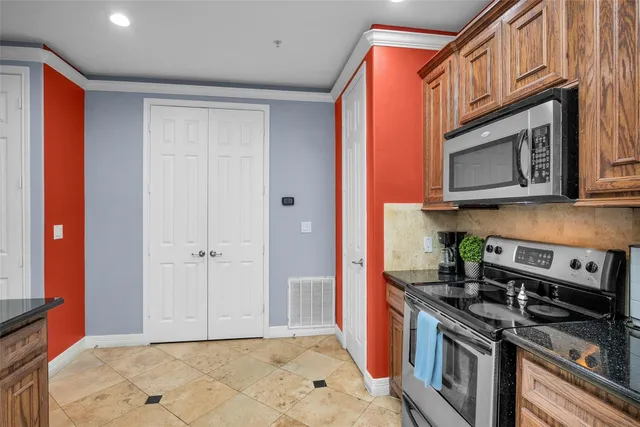 a kitchen with stainless steel appliances granite countertop a stove a microwave and a cabinets