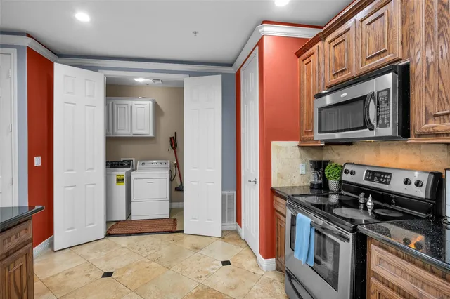 a kitchen with stainless steel appliances granite countertop a stove microwave and refrigerator