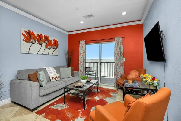 a living room with furniture a flat screen tv and a floor to ceiling window