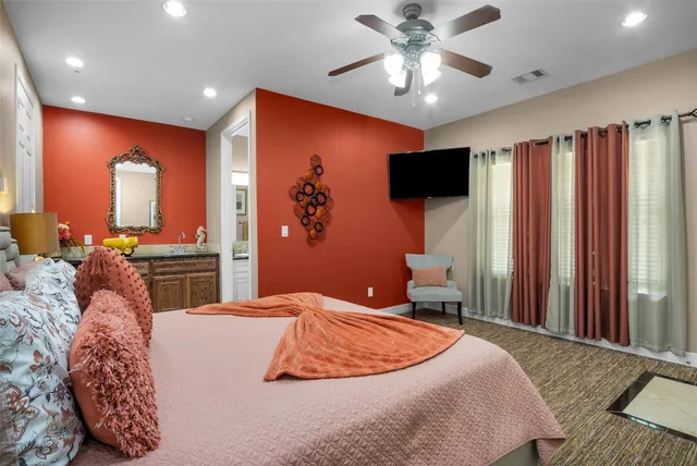 a bedroom with a large bed and a flat screen tv