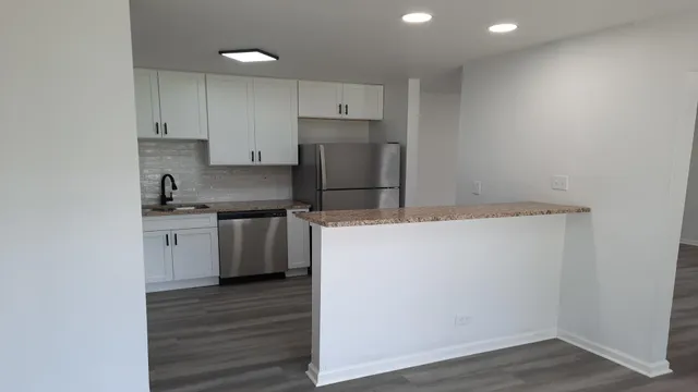 a kitchen with a sink cabinets and wooden floor